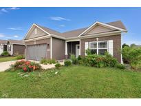Charming single-Gathering home featuring brick and vinyl siding, a two-car garage, and a beautifully landscaped front yard at 757 Carson Ln, Greenfield, IN 46140
