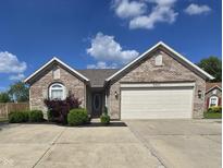 Charming single-story brick home with well-manicured landscaping and attached two-car garage at 8460 Ferguson Cir, Avon, IN 46123