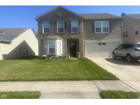 Two-story home featuring a brick facade, well-maintained lawn, and an attached two-car garage at 12536 Teacup Ne Way, Indianapolis, IN 46235