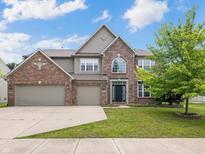 Attractive two-story brick home with a well-manicured lawn and a three-car garage at 12997 Bartlett Dr, Fishers, IN 46037