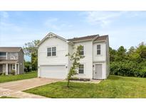 Charming two-story home features a white exterior, attached garage, and well-manicured front yard at 1338 Delacorte Cir, Shelbyville, IN 46176
