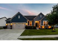 Charming home showcasing blue siding, brick accents, manicured lawn, and inviting two-car garage at 19009 Beverly Shones Ln, Noblesville, IN 46062