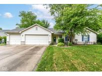 Charming single-story home boasts a two-car garage and beautifully landscaped front yard and great curb appeal at 20845 Summit Rd, Noblesville, IN 46062