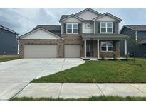 Charming two-story home featuring a two-car garage and well-manicured front yard at 210 Ames Dr, Whiteland, IN 46184