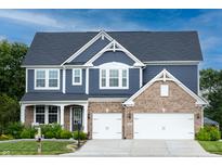 Beautiful two-story home with a brick and blue facade, complemented by a well-manicured lawn and a two-car garage at 2245 Meadow Crk, Avon, IN 46123