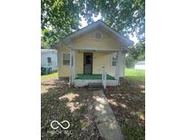 Charming bungalow featuring a covered porch and light yellow siding at 3026 S Rybolt Ave, Indianapolis, IN 46241