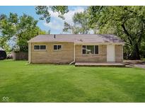 Charming single-story home showcasing a stone facade, green lawn, and mature trees at 3538 N Elizabeth St, Indianapolis, IN 46226