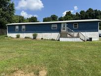 Charming home with a blue exterior, inviting entrance, and a lush green lawn at 4466 Buffalo Ln, Martinsville, IN 46151