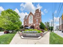 Beautiful brick building with architectural details, blue skies, and colorful landscaping at 501 Fletcher Ave # A, Indianapolis, IN 46203