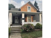 Charming home's front porch with swing, flowers, and well maintained landscape at 597 W Adams St, Franklin, IN 46131