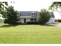 Charming two-story home with a well-manicured lawn, a red front door and inviting curb appeal at 6052 N Deckshire Ln, Shirley, IN 47384