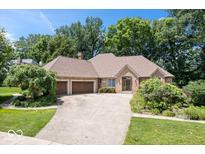 Charming brick ranch with manicured lawn, mature trees, and attached two-car garage at 7250 Royal Oakland Dr, Indianapolis, IN 46236