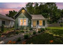 Charming home with well-maintained landscaping, green siding and inviting pathway to the front door at 761 N Holmes Ave, Indianapolis, IN 46222