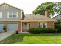 Charming home featuring mixed siding, brick, an attached two car garage and a neatly manicured lawn at 7612 Farm View E Cir, Indianapolis, IN 46256