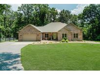 Beautiful brick home featuring an attached garage and a well-manicured lawn surrounded by mature trees at 1125 Observatory Rd, Martinsville, IN 46151