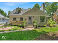 Charming home with a manicured front lawn, flower boxes and a cozy brick pathway at 1149 E 56Th St, Indianapolis, IN 46220