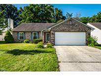 Charming single-story brick home featuring a well-manicured lawn, attached two-car garage and shuttered windows at 12922 St Andrews Way, Fishers, IN 46038