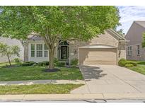 Charming brick home featuring manicured lawn, mature tree, attached two-car garage, and well-maintained landscaping at 13172 Duval Dr, Fishers, IN 46037
