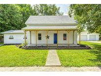 Charming home featuring a covered front porch, tidy landscaping, and inviting curb appeal at 209 Howard Ave, Arcadia, IN 46030