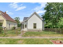 Charming home with white siding, a gray roof, and a small front yard with chainlink fence at 2400 Walnut St, Anderson, IN 46016