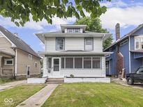 Charming two-story home featuring a covered front porch and landscaped front yard at 3936 Graceland Ave, Indianapolis, IN 46208