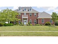 Beautiful two-story brick home with a well-manicured lawn and inviting front porch at 4415 Summer Dr, Zionsville, IN 46077