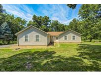 Charming single-story home with verdant lawn, surrounded by mature trees and a blue sky at 494 W Greencastle Rd, Mooresville, IN 46158