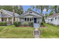 Charming bungalow with a well-maintained front yard, shrubbery, and inviting blue front door at 5209 E North St, Indianapolis, IN 46219