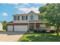 Two-story home with a two-car garage, brick accents, a well-manicured lawn, and a charming front porch at 6045 Copeland Mills Ct, Indianapolis, IN 46221