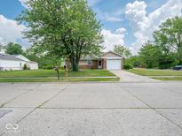 Charming single-story home with a brick facade, attached garage, and well-maintained front lawn at 7645 Inverness Dr, Indianapolis, IN 46237