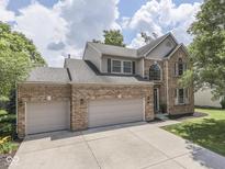 Charming two-story brick home featuring an attached two-car garage and well-maintained landscaping at 8415 Alcona Dr, Indianapolis, IN 46237