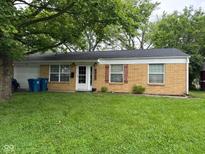 Charming brick ranch-style home with a well-maintained lawn, quaint shutters, and attached garage at 8540 E 37Th Pl, Indianapolis, IN 46226