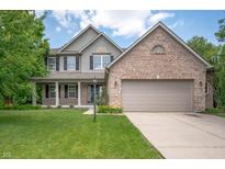 Charming two-story home featuring a brick facade, vinyl siding, and a well-manicured front lawn at 8578 Nolan Dr, Fishers, IN 46038