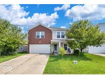 Charming two-story home with brick accents, a front yard, and attached garage at 951 Curlew Ln, Greenwood, IN 46143