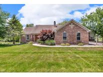 Brick ranch style home with a well-maintained lawn and a walkway leading to the front door at 10174 N County Road 471 E, Pittsboro, IN 46167
