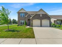 Charming two-story brick home featuring a two-car garage, well-manicured lawn, and beautiful landscaping at 10917 Hunter Lake Ln, Indianapolis, IN 46239