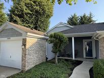 Charming single-story home showcasing a well-manicured front yard and attached garage with brick accents at 20876 Waterscape Way, Noblesville, IN 46062