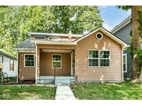Charming single-story home with well-kept landscaping and a welcoming front porch at 2136 Ringgold Ave, Indianapolis, IN 46203