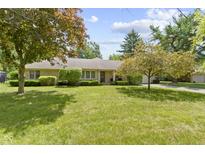 Charming stone home featuring a well-manicured lawn and mature trees at 2315 Elm Swamp Rd, Lebanon, IN 46052
