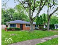 Charming single-story home with a brick facade and a well-maintained lawn, framed by mature trees at 3513 Ireland Dr, Indianapolis, IN 46235