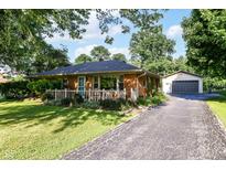 Charming brick ranch home features a covered front porch, mature trees and a detached garage at 3515 Lindenwald Dr, Indianapolis, IN 46217