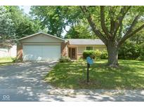 Charming one-story home features a well-maintained lawn, mature trees, a two-car garage and inviting curb appeal at 5530 Pilgrim Dr, Indianapolis, IN 46254