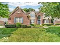 Charming two-story brick home with manicured lawn, lush shrubbery and beautiful curb appeal at 5865 Osage Dr, Carmel, IN 46033