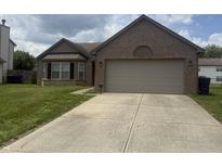 Charming brick home featuring an attached two car garage and a well-manicured front lawn at 5954 Honeywell Dr, Indianapolis, IN 46236