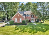 Charming brick home with lush landscaping, blue shutters and a well-manicured lawn at 6374 Timberbluff Cir, Avon, IN 46123