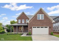Beautiful two-story brick home with a covered front porch, an attached two-car garage, and well-manicured lawn at 6553 Stone Pointe Way, Indianapolis, IN 46237