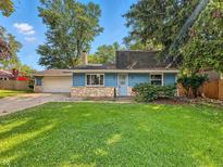 Charming blue ranch-style home featuring a stone facade and well-manicured lawn at 6739 Westdrum Rd, Indianapolis, IN 46241