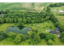 Stunning aerial view of estate with pool, pond with dock, barn and pastures, surrounded by mature trees and lush greenery at 750 N 500 W, Lebanon, IN 46052