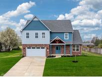 Charming two-story home featuring a brick facade, light blue accents, and a well-manicured lawn at 7604 Brownstone Ct, Greenfield, IN 46140