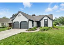 Charming home with two-car garage, manicured lawn, and inviting front entrance at 7914 Trotwood Cir, Indianapolis, IN 46256